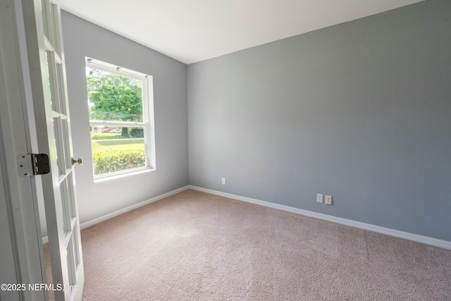 carpeted spare room with baseboards