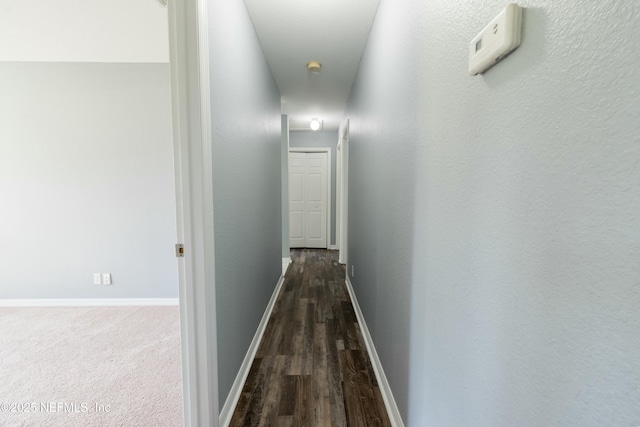 hall with dark wood finished floors and baseboards