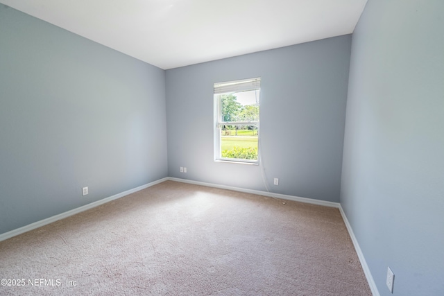 carpeted spare room featuring baseboards
