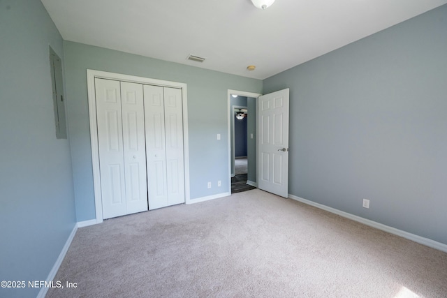 unfurnished bedroom with a closet, carpet, visible vents, and baseboards