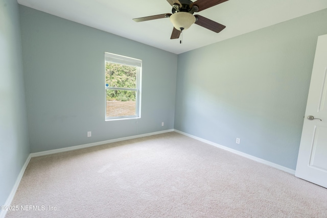 spare room featuring carpet, baseboards, and ceiling fan
