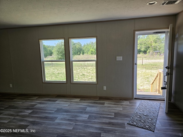 interior space featuring wood finished floors, a textured ceiling, and visible vents