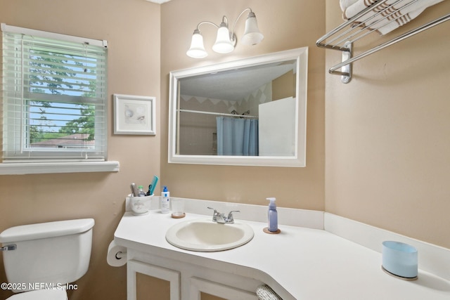 full bathroom featuring toilet, vanity, and curtained shower