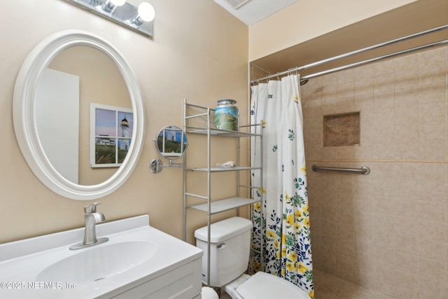 full bathroom with a tile shower, toilet, and vanity