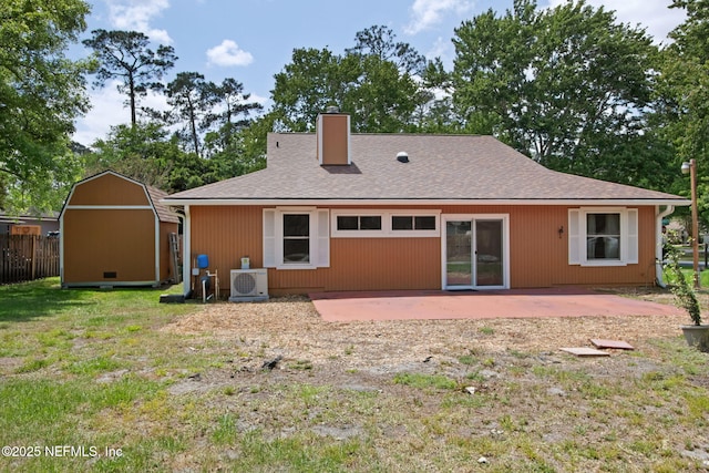 back of house with an outdoor structure, a chimney, a patio area, ac unit, and a storage shed