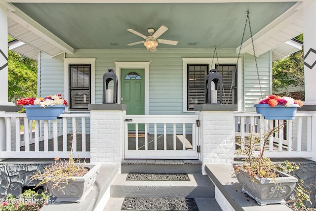 property entrance with covered porch, fence, and a ceiling fan