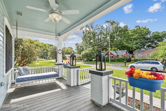 deck with a porch, ceiling fan, visible vents, and a yard