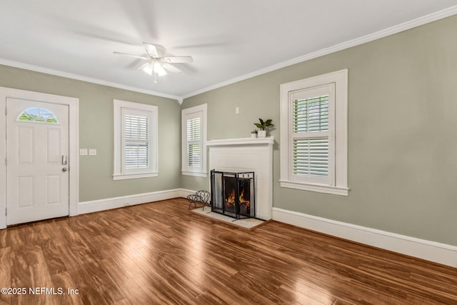 unfurnished living room featuring ornamental molding, a ceiling fan, a fireplace with flush hearth, and a healthy amount of sunlight