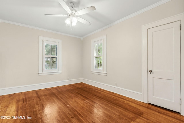 empty room featuring a ceiling fan, wood finished floors, a healthy amount of sunlight, and ornamental molding
