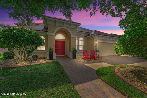mediterranean / spanish house featuring driveway, a garage, and stucco siding