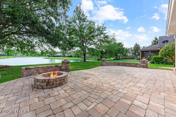 view of patio / terrace featuring a water view and a fire pit