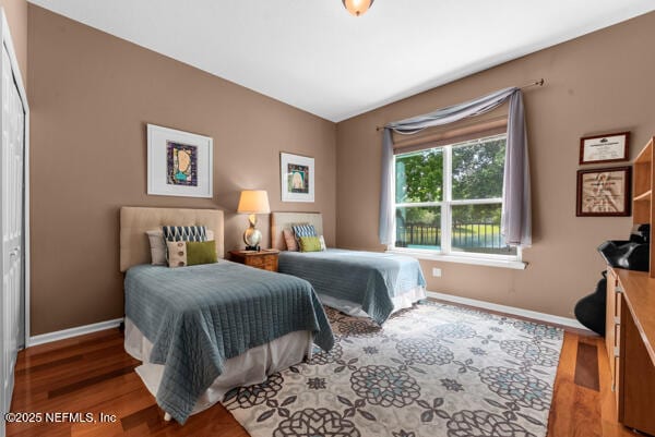bedroom with wood finished floors and baseboards
