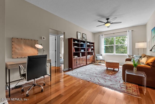 living area featuring a ceiling fan and wood finished floors