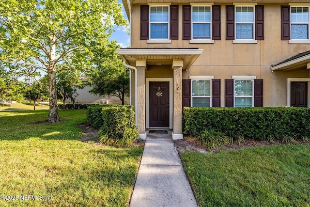 425 Oasis Ln, Orange Park, FL 32073 - view of exterior entry with a lawn and stucco siding
