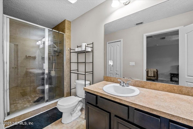 425 Oasis Ln, Orange Park, FL 32073 - bathroom featuring a textured ceiling, a stall shower, vanity, toilet, and visible vents