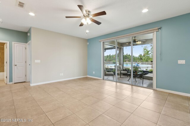 unfurnished room with baseboards, ceiling fan, visible vents, and light tile patterned floors