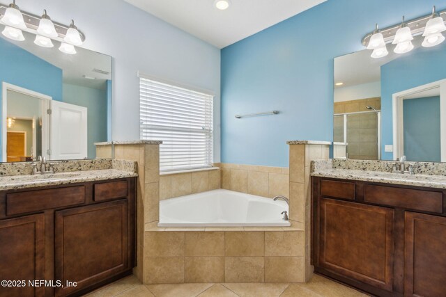 full bathroom with a sink, tile patterned floors, two vanities, a garden tub, and a stall shower
