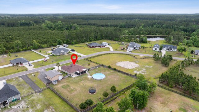 drone / aerial view with a water view and a forest view