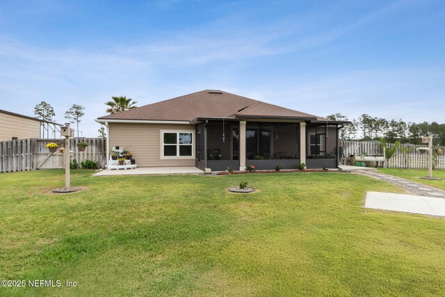 back of house featuring a sunroom, a lawn, fence, and a patio