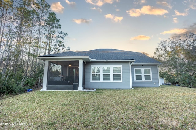 1209 Hammock Dunes Dr, Jacksonville, FL 32221 - back of house at dusk featuring a sunroom, a yard, and a shingled roof