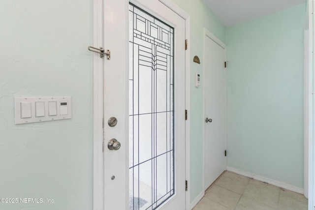 entryway featuring light tile patterned floors and baseboards