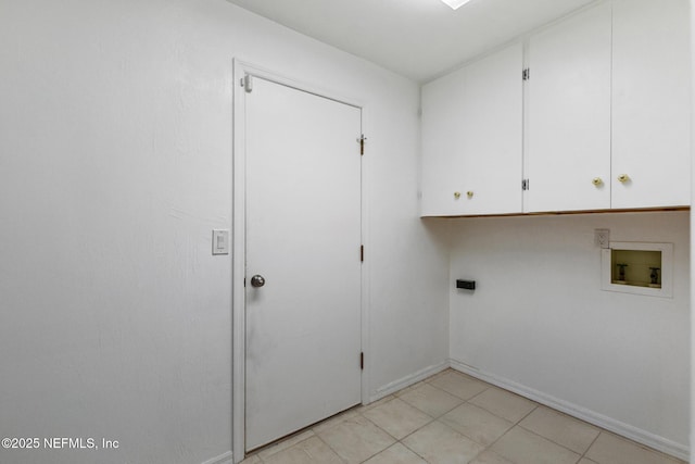 clothes washing area featuring baseboards, cabinet space, and washer hookup