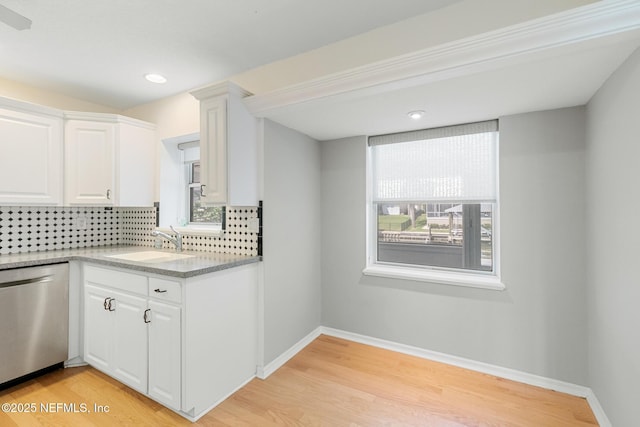 kitchen with plenty of natural light, dishwasher, decorative backsplash, and a sink