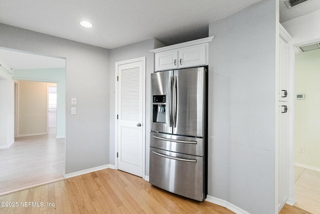 kitchen with recessed lighting, light wood-style flooring, white cabinetry, baseboards, and stainless steel fridge with ice dispenser