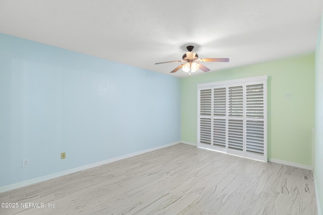 empty room with baseboards, wood finished floors, and ceiling fan