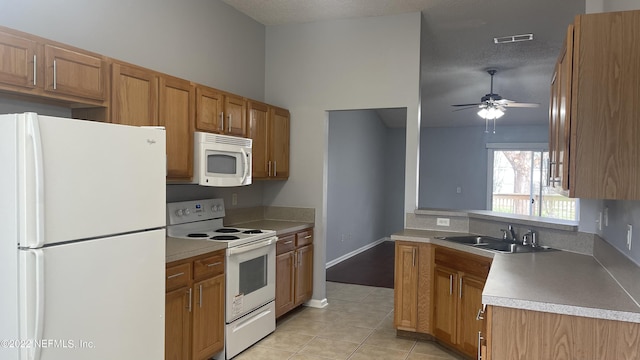 kitchen featuring a sink, light countertops, light tile patterned flooring, white appliances, and a ceiling fan