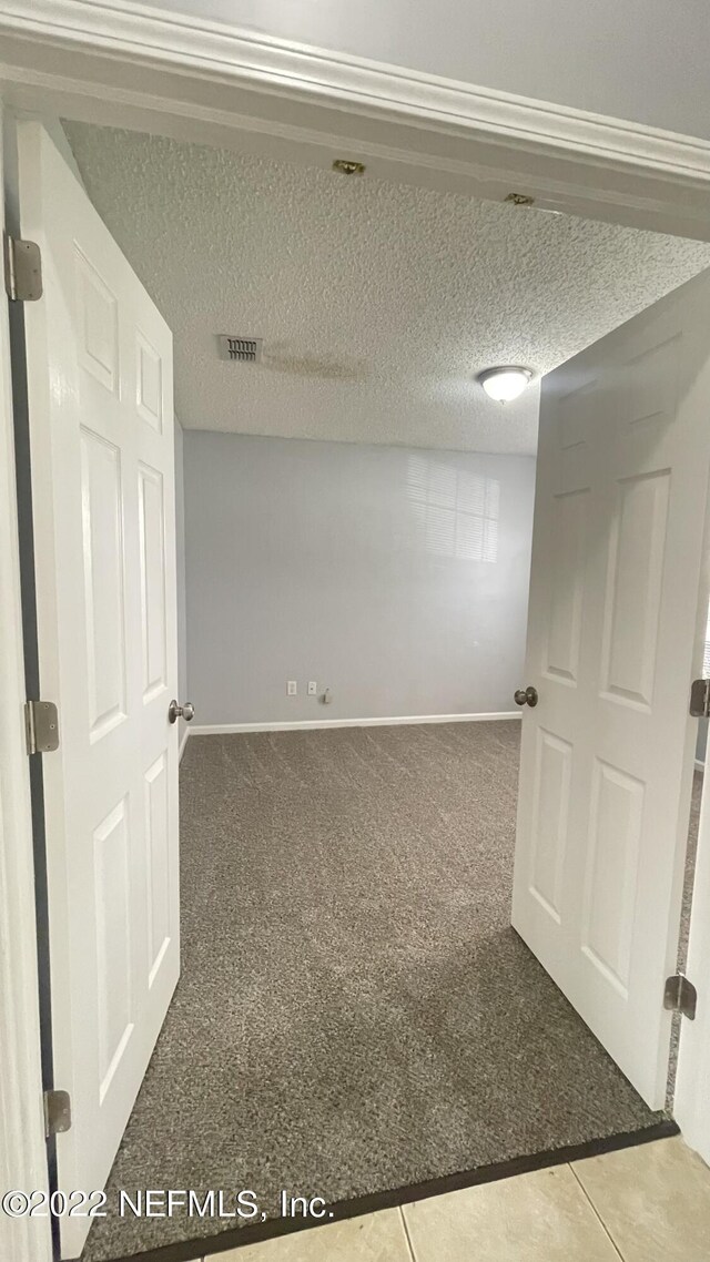below grade area featuring visible vents, carpet, and baseboards
