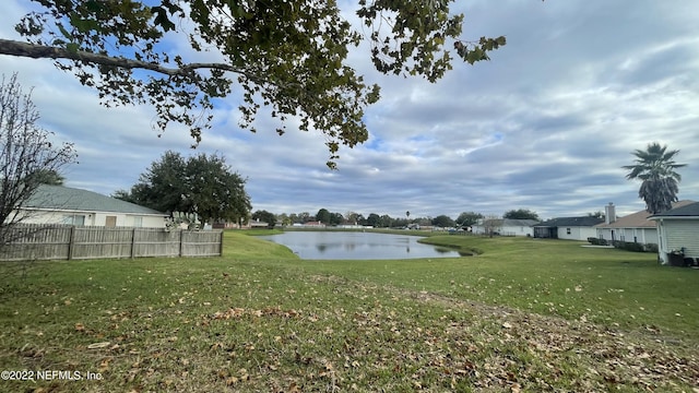 view of yard featuring fence and a water view