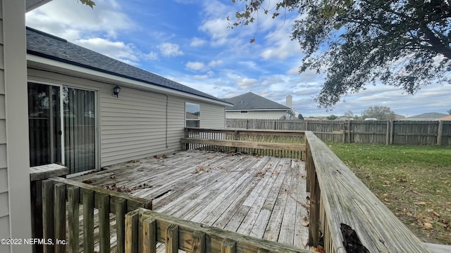wooden terrace with a lawn and a fenced backyard