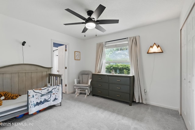 bedroom with ceiling fan, a closet, and light carpet