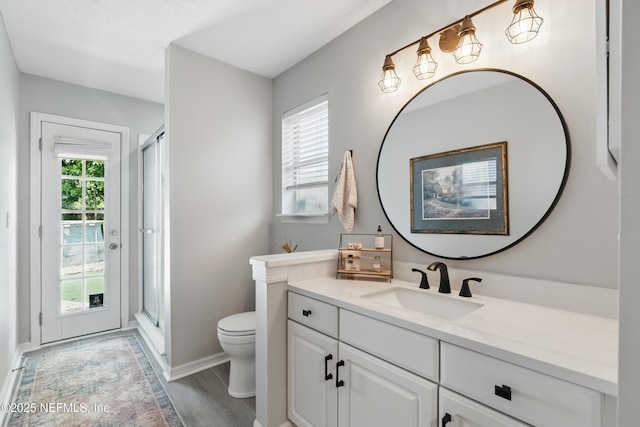 full bath featuring a shower stall, toilet, wood finished floors, and baseboards