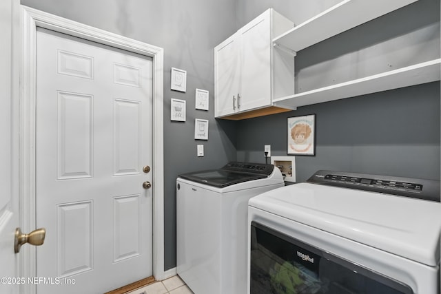 laundry room with separate washer and dryer, light tile patterned flooring, and cabinet space