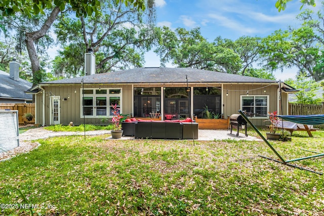 rear view of property featuring a lawn, fence, an outdoor living space, and a patio