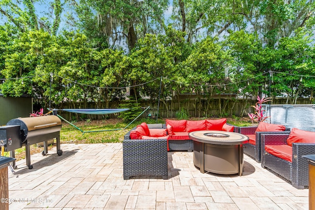 view of patio featuring a fenced backyard and an outdoor living space with a fire pit