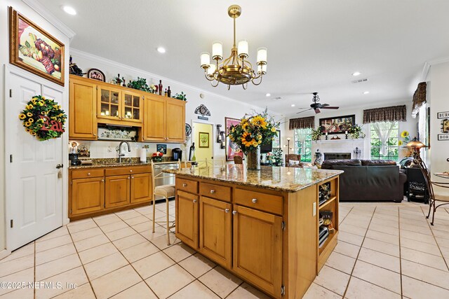 104 Twin Cedar Ct, Ponte Vedra Beach, FL 32082 - kitchen with a center island, a sink, ceiling fan with notable chandelier, light tile patterned floors, and ornamental molding