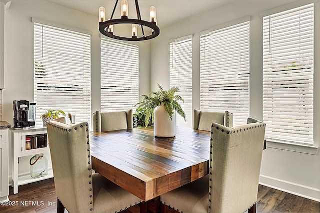 dining area featuring baseboards, a chandelier, and dark wood-type flooring