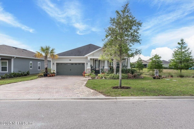 view of front of house with a garage, a front yard, and decorative driveway