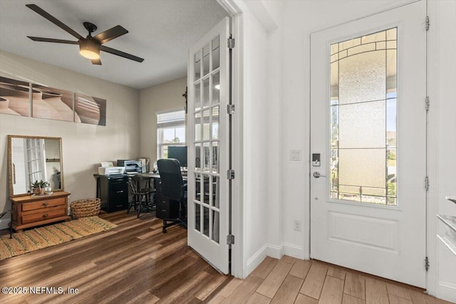 entryway featuring wood finished floors, a ceiling fan, and baseboards