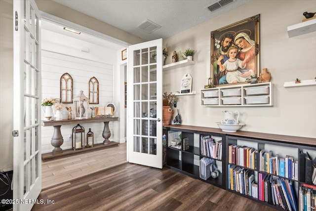 interior space featuring wood finished floors, visible vents, and french doors