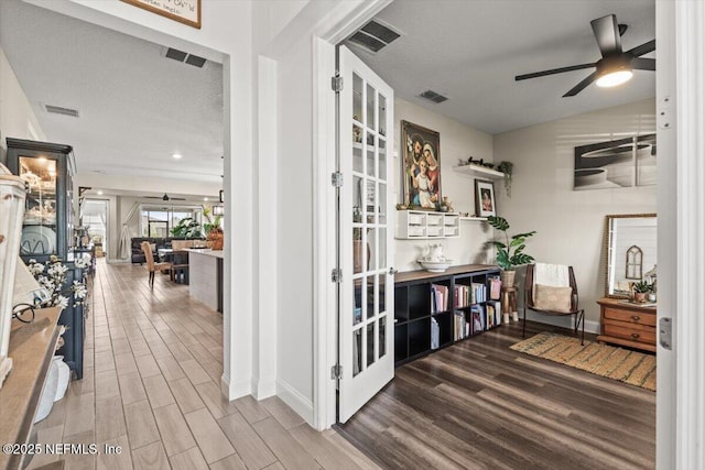 corridor featuring wood finished floors, visible vents, and french doors