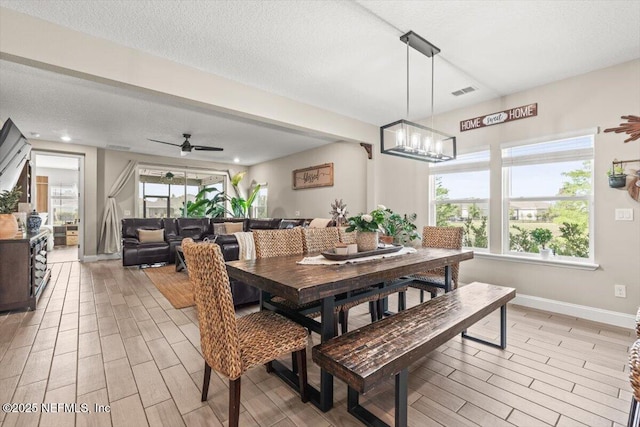 dining space with baseboards, wood finish floors, and a textured ceiling