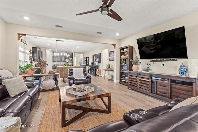 living room featuring recessed lighting, light wood-style flooring, visible vents, and ceiling fan