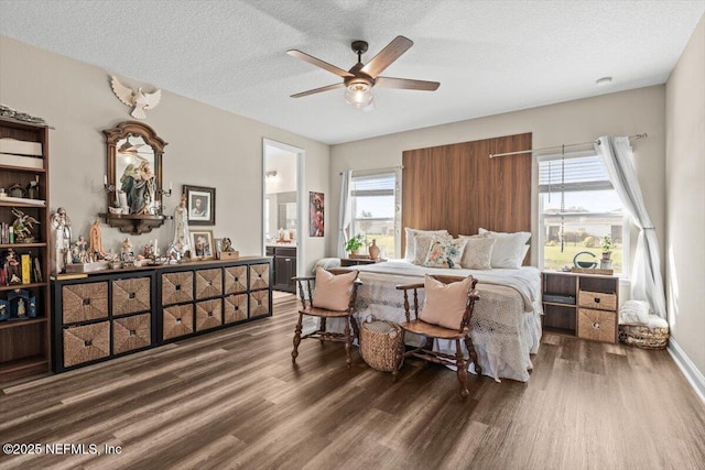 bedroom featuring multiple windows, wood finished floors, a textured ceiling, and ensuite bathroom