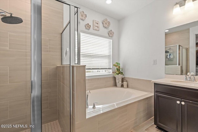 bathroom with a garden tub, vanity, and a stall shower