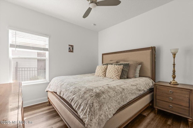 bedroom with baseboards, ceiling fan, and dark wood finished floors