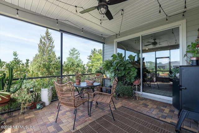 sunroom / solarium featuring a ceiling fan and outdoor dining area